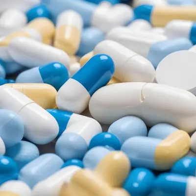 Pile Of Blue White And Yellow Pills And Capsules Pharmaceutical Drugs Medicine Health And Wellness Concept 12 Cc30