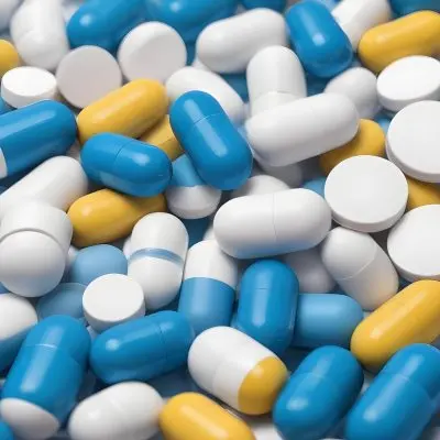 Pile Of Blue White And Yellow Pills And Capsules Pharmaceutical Drugs Medicine Health And Wellness Concept 3 C4ce
