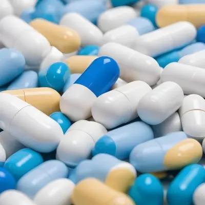 Pile Of Blue White And Yellow Pills And Capsules Pharmaceutical Drugs Medicine Health And Wellness Concept 9 E6d6