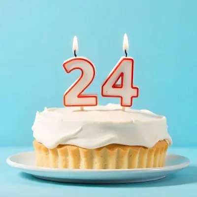 A Birthday Cake With White Frosting And A Candle In The Shape Of The Number 24 Light Blue Background 12 42ad
