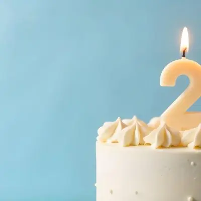 A Birthday Cake With White Frosting And A Candle In The Shape Of The Number 24 Light Blue Background 14 0071