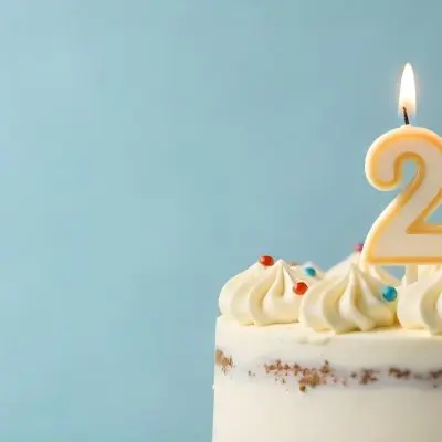 A Birthday Cake With White Frosting And A Candle In The Shape Of The Number 24 Light Blue Background 6 Bbd8