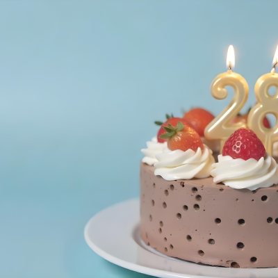 Chocolate Cake With Strawberries And Cream Two Candles With The Number 28 On Top Of A White Plate In A Blue Background 14 7efe