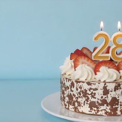 Chocolate Cake With Strawberries And Cream Two Candles With The Number 28 On Top Of A White Plate In A Blue Background 4 311e