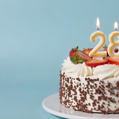 Chocolate Cake With Strawberries And Cream Two Candles With The Number 28 On Top Of A White Plate In A Blue Background 6 1ba4