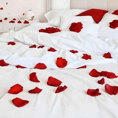 White Bed With Red Pillows And Sheets Covered With Red Rose Petals In A Bedroom 1 0f36
