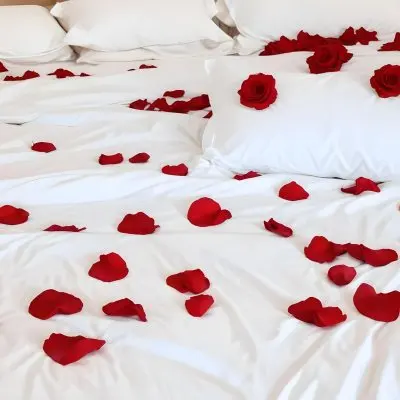 White Bed With Red Pillows And Sheets Covered With Red Rose Petals In A Bedroom 7 B43f