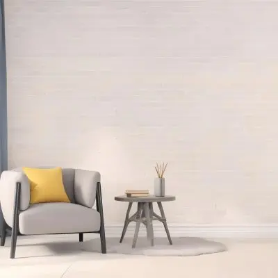 A Gray Armchair With A White Pillow Next To A Small Table With A Book And Some Sticks In A Yellow Room 2 9671