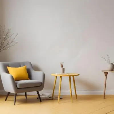 A Gray Armchair With A White Pillow Next To A Small Table With A Book And Some Sticks In A Yellow Room 20 2358