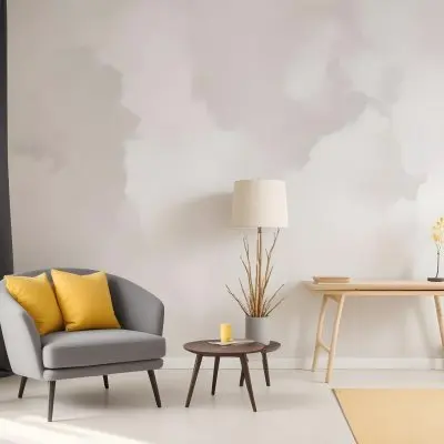 A Gray Armchair With A White Pillow Next To A Small Table With A Book And Some Sticks In A Yellow Room 34 3a3f