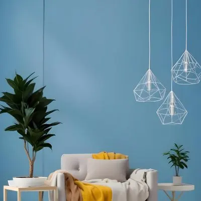 A Modern Living Room With A White Sofa A Potted Plant And Geometric Pendant Lights Hanging From The Ceiling Against A Blue Wall 9 4293