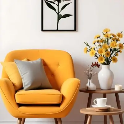 Yellow Armchair With A Flower Pillow Next To A Wooden Table With A Vase Of White Flowers A Cup Of Tea And A Candle With A Yellow Wall And A Framed Picture In The Background 23 E389