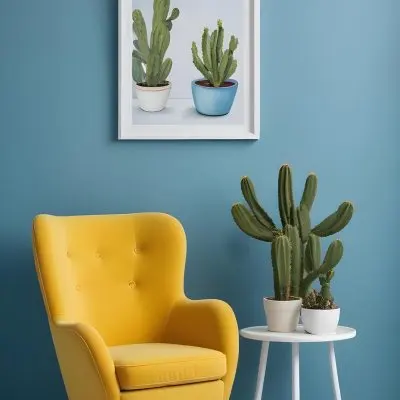 Yellow Armchair With A White Frame On The Wall And A White Table With Cactuses In A Blue Room 11 3af3