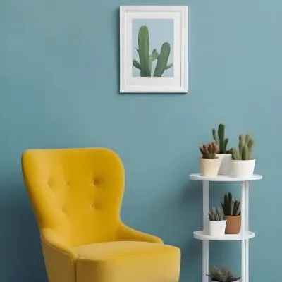 Yellow Armchair With A White Frame On The Wall And A White Table With Cactuses In A Blue Room 19 4a03