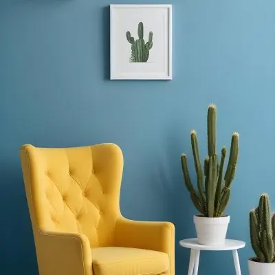 Yellow Armchair With A White Frame On The Wall And A White Table With Cactuses In A Blue Room 2 C9b6