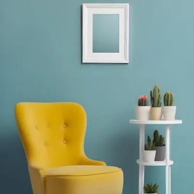 Yellow Armchair With A White Frame On The Wall And A White Table With Cactuses In A Blue Room 25 3e7b