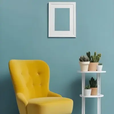 Yellow Armchair With A White Frame On The Wall And A White Table With Cactuses In A Blue Room 27 2254