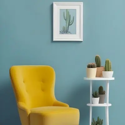 Yellow Armchair With A White Frame On The Wall And A White Table With Cactuses In A Blue Room 29 Cd62