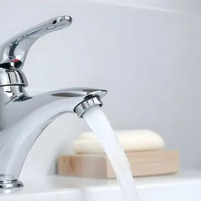 A Chrome Faucet With Water Running In A White Sink With A Soap Dish In The Background 4 D7b1