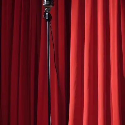 A Microphone On A Stage With Red Curtains In The Background 14 Bfe3