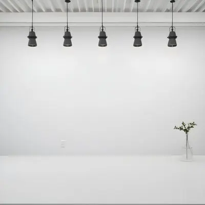 A Minimalist White Room With A High Ceiling And Hanging Pendant Lights 1 6633