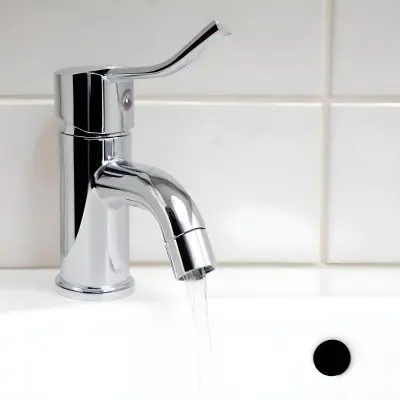 Chrome Faucet With Running Water Over A White Sink In A Bathroom With White Tiles 16 43eb