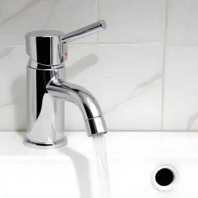 Chrome Faucet With Running Water Over A White Sink In A Bathroom With White Tiles 23 63da