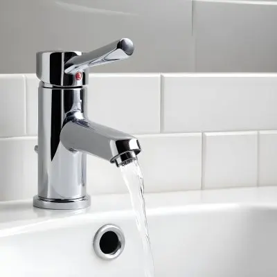 Chrome Faucet With Running Water Over A White Sink In A Bathroom With White Tiles 38 5f20