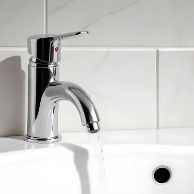 Chrome Faucet With Running Water Over A White Sink In A Bathroom With White Tiles 6 Ce4c