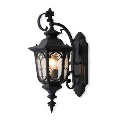 An Ornate Black Metal Outdoor Wall Sconce With A Glass Pane Design Mounted On A Brick Wall 8 6ecd