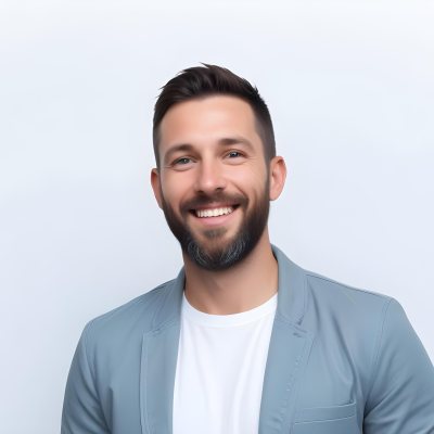 A White Man 35 Years Old With Short Dark Hair And A Beard Wearing A White T Shirt And A Gray Jacket Smiling In A White Background 38 E3ef