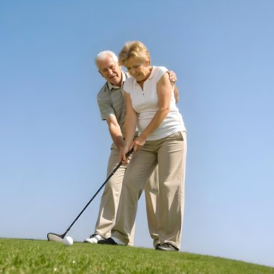 An Elderly Caucasian Couple A Man And A Woman Standing On A Grassy Hill And Holding Golf Clubs 6 82e1