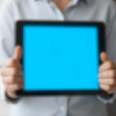 A Person Holding A Tablet With A Blank Blue Screen The Background Is Blurred And Out Of Focus The Person Is Wearing A White Shirt 34 5389