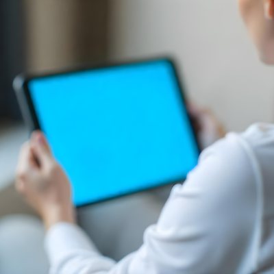 A Person Holding A Tablet With A Blank Blue Screen The Background Is Blurred And Out Of Focus The Person Is Wearing A White Shirt 8 1195