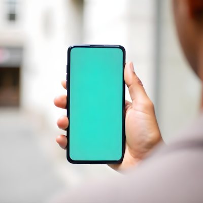 Black Man Holding A Smartphone With A Blank Turquoise Screen The Background Is A Blurred City Street 7 4c60