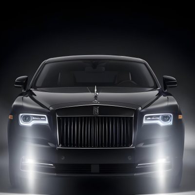 A Sleek Dark Colored Luxury Sedan With A Prominent Grille Featuring The Rolls Royce Logo Illuminated Headlights And A Minimalist Elegant Design 18 091c